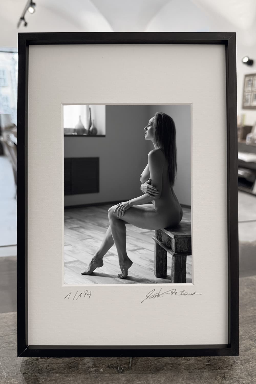 „Sit. Stay. Smile.“ – gerahmter Print am Tisch präsentiert – limitierte fine art aktfotografie