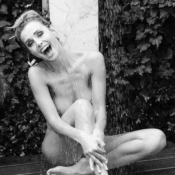 „Garden Hose Baptism“ – Schwarzweiß-Akt im Außenbereich unter Wasserstrahl, spielerisch und roh – limitierte fine art aktfotografie