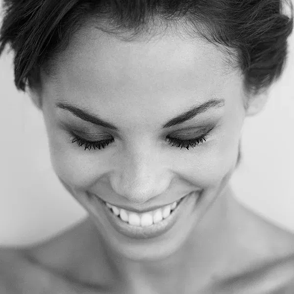 „With Your Eyes Closed“ – erotische Fotografie, die durch das Lächeln und den intimen Moment fasziniert.